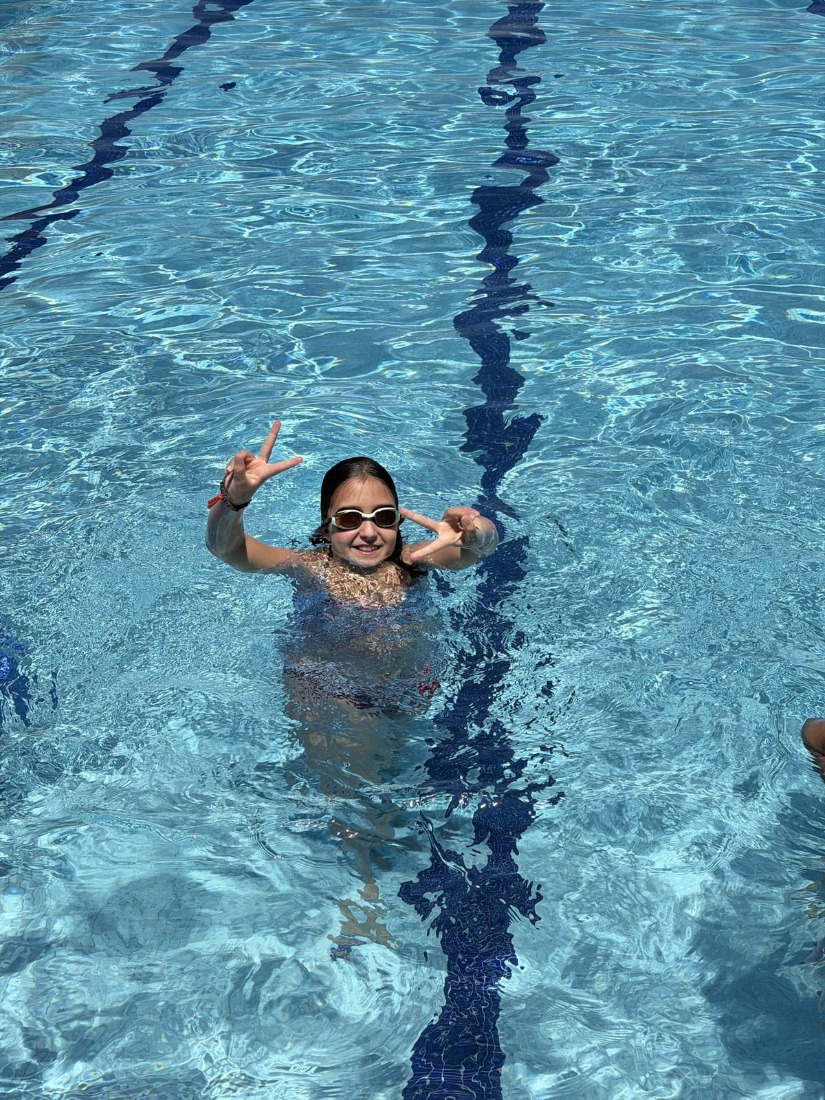 Una alumna somrient dins l'aigua de la piscina